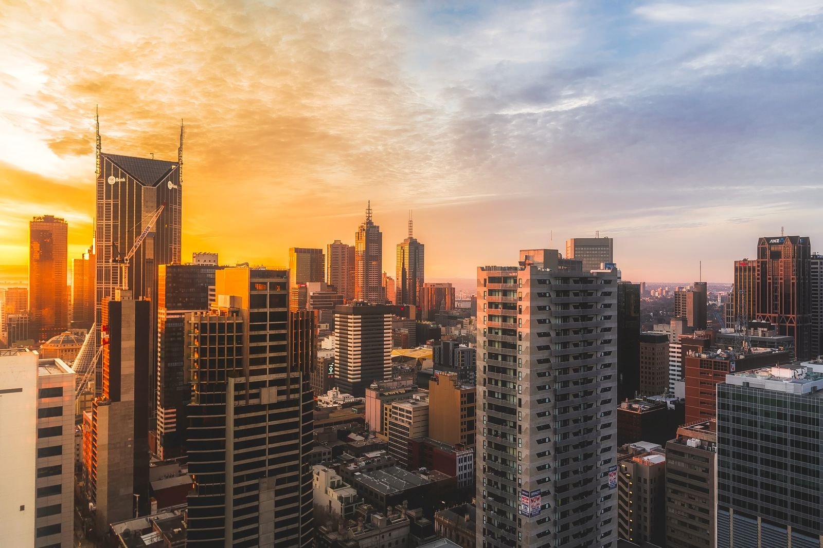 Commercial towers glowing against a golden dusk city skyline