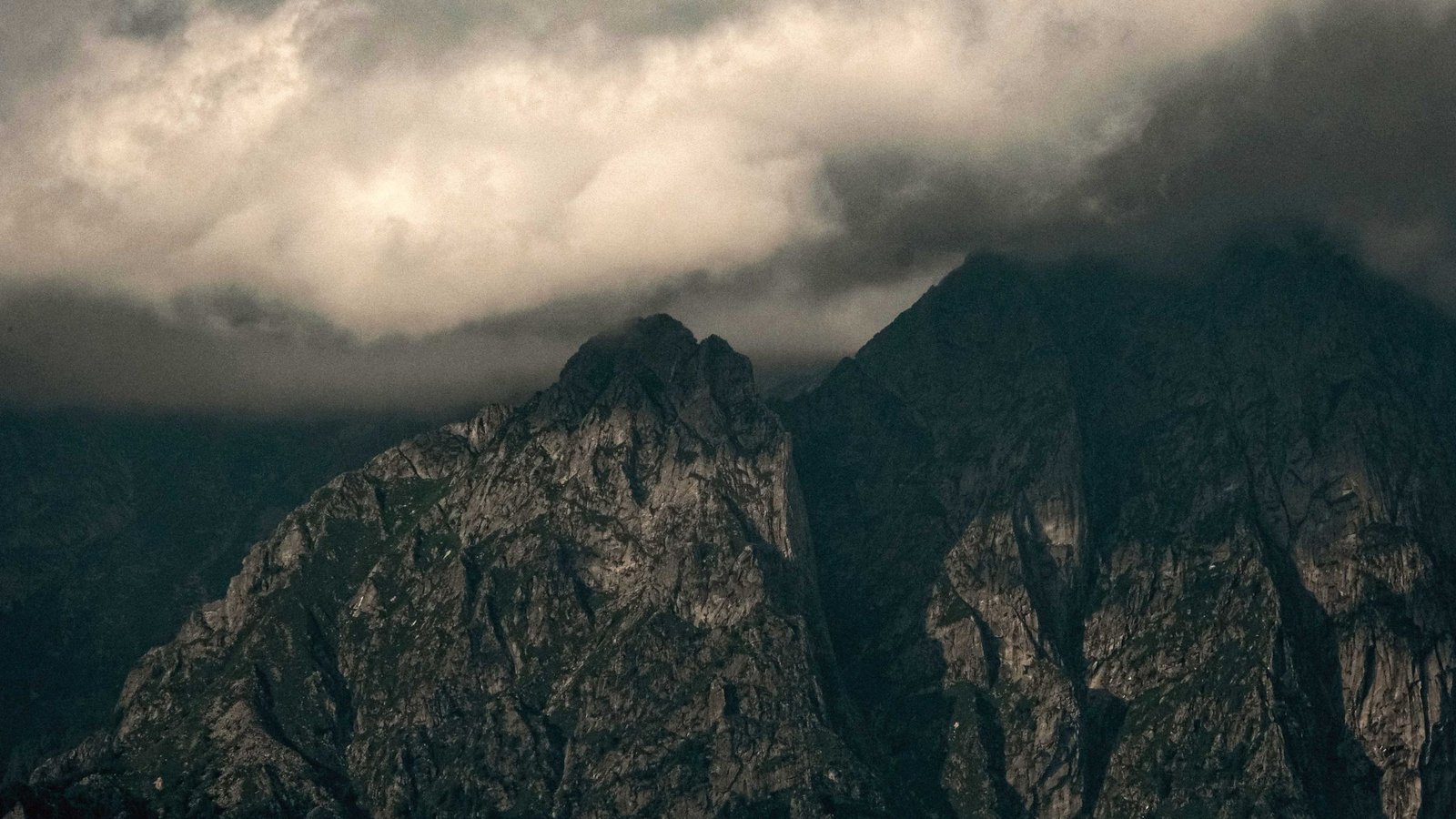 A dark mountain ridge under heavy cloud