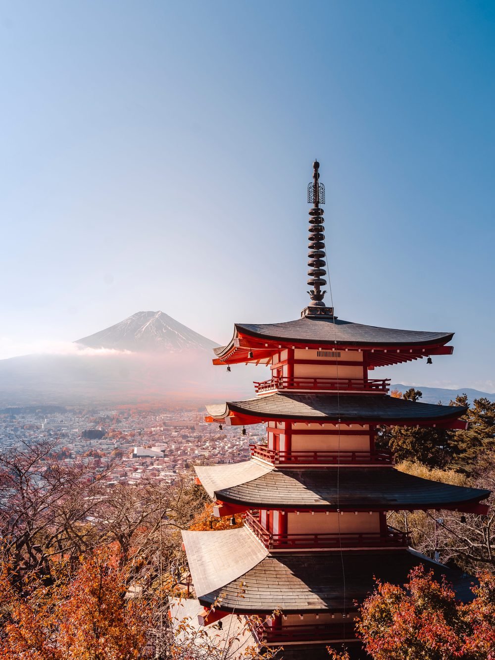 A traditional Japanese pagoda among trees with a mountain behind it