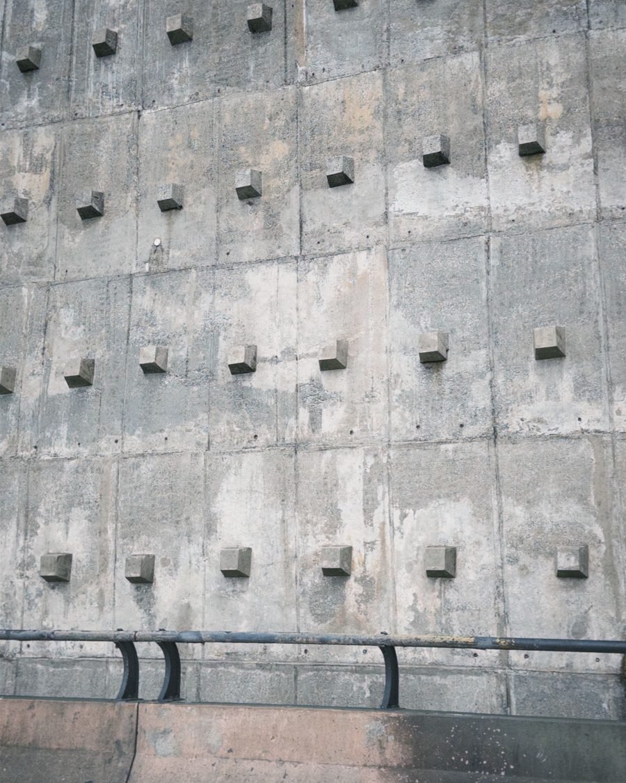 Board-formed in-situ concrete wall showing the timber grain and the recessed form-tie plates