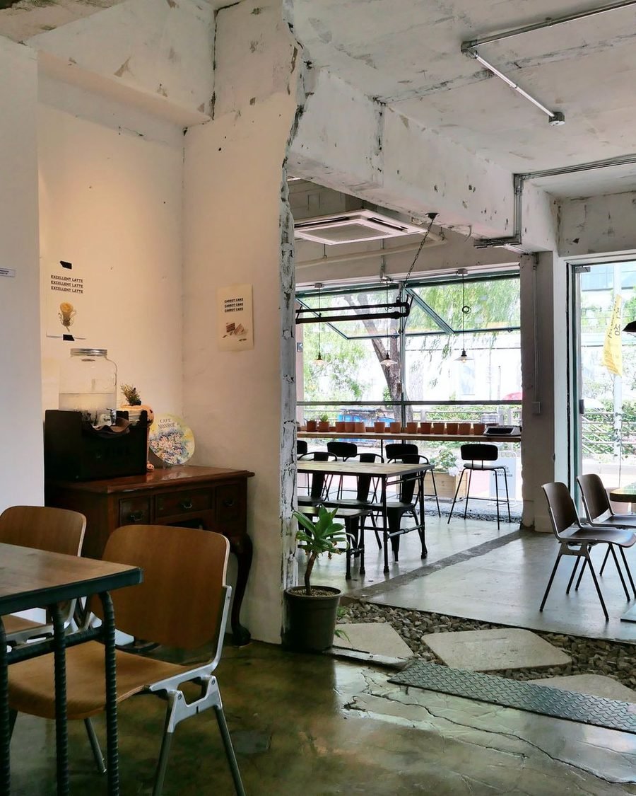 Retail interior with an exposed concrete ceiling, breeze-block screen wall and a mixed-timber display table