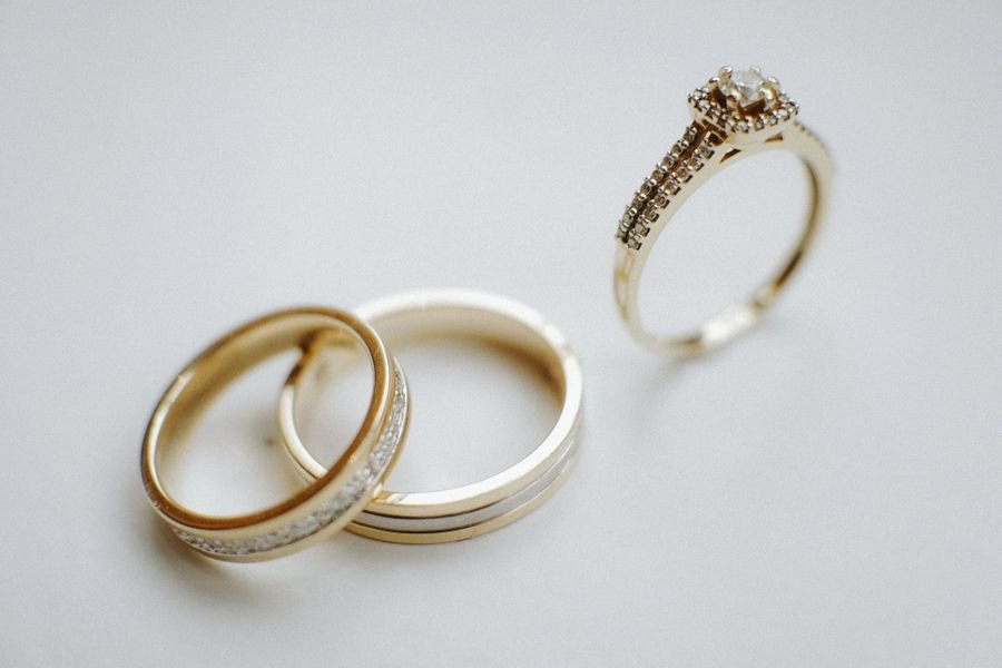 A 0.42 carat round solitaire ring in 18-karat gold shown beside two plain gold bands