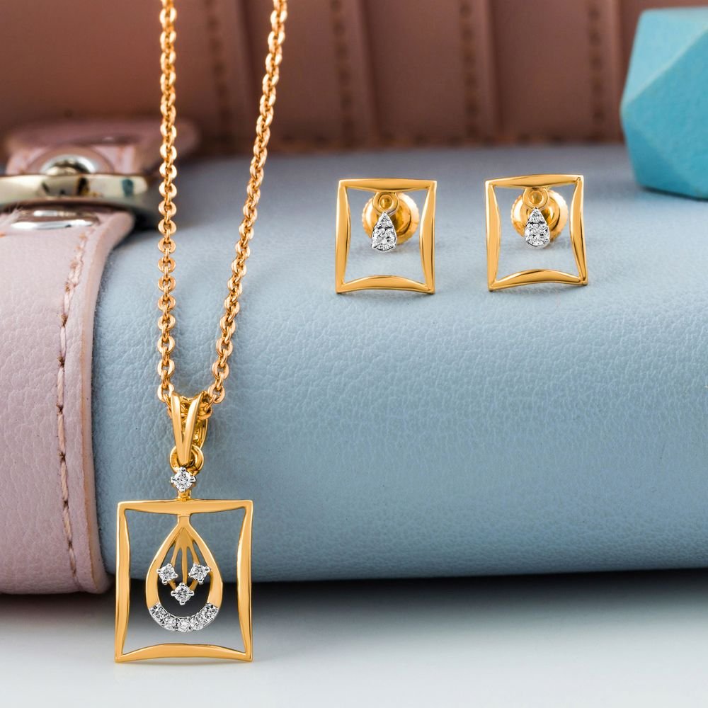 A modern gold and diamond pendant with matching square studs resting on pastel leather surface