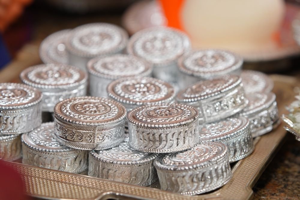 Stack of engraved silver boxes arranged on silver tray