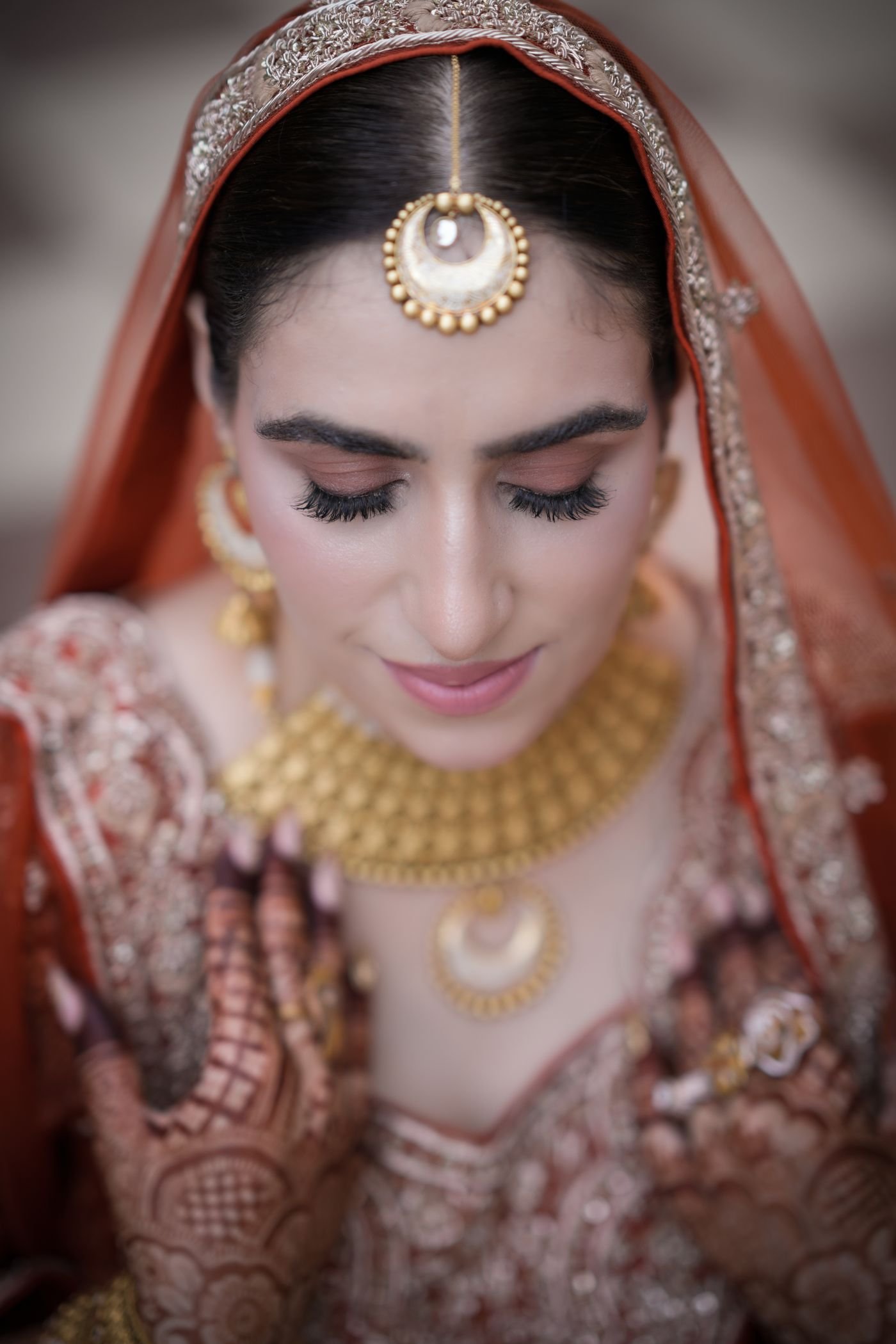 Indian royal bride adorned in 22K handcrafted gold bridal choker and maang tikka